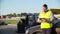 Man in Reflective Safety Vest typing on a laptop on the background of his colleagues