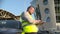 Man in Reflective Safety Vest typing on a laptop fixed to the hood of the car