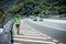 Man in reflective vest arranges a warning triangle, car breakdown on the highway
