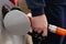 Man refueling a car in Europe with a pistol in his hand. Gas station - refueling, diesel and gasoline. The man fills a tank of a