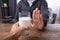 Man Refusing Glass Of Milk Offered By Person