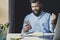 Man rejoices in victory while looking at screen of smartphone. Worker at desk with laptop and notebook. Male getting high-paid job