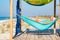 Man relaxes in a hammock on abandoned bungalow veranda