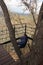 Man relaxes in a hanging net of a glamping cabin in the middle of the forest, thinks and meditates about life and its problems