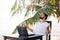 Man relaxing on the beach and doing yoga with laptop, freelancer workplace, dream job