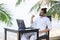 Man relaxing on the beach with laptop, freelancer show win