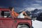 Man Relaxing On Car Hood Against Mountains