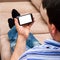 A man relaxing on a couch looking at a smartphone