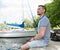 A Man relaxing dreaming and enjoying the view on nature and lake. Handsome young man posing outdoors in port