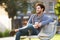 Man Relaxing On Park Bench With Takeaway Coffee