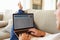 Man Relaxing On Sofa Using Internet Banking On Laptop Computer