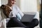 Man Relaxing On Sofa Using With Pet Bulldog Laptop Computer