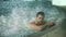 Man relaxing in spa on vacation. Male resting in jacuzzi at wellness center