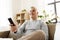 Man with remote control watching tv at home