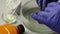 A man removes corrosion from copper coins in a container with phosphoric acid, soda and sulfuric ointment for patination