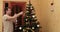 A man removes a garland from a Christmas tree