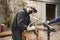 Man removing the paint of an orange bicycle frame during a bike renovation work