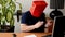 Man removing red paper bag from his head but there is black balaclava under  it