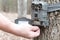 A man removing the SD Card from a trail camera.