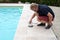 Man removing a skimmer basket from a swimming pool