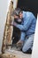 Man removing termite damaged wood from wall