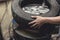 A man removing a tire from the rim after using a tire bead breaker at a vulcanizing shop