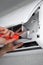 A man repairing an air conditioner at home. technician repairman. the man unscrews the screw in the air conditioner for cleaning.