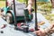 A man is repairing a battery-powered lawnmower. The electric toggle switch to start the engine is defective and needs to be