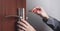 Man repairing door lock. Hand of the repairman with a screwdriver