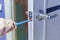 Man repairing the doorknob with screwdriver. worker`s hand installing new door locker