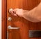 Man repairing wooden door lock with screwdriver. Close-up of repairing