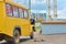 Man repairing yellow bus