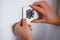 A man repairs a lighting switch. Close-up on hand. Electrician work