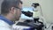 Man researcher works with binocular microscope in a laboratory. concept analysis, spbas chemist