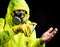 Man in respirator and glove treating his hand with antiseptic over black background