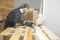 Man in respirator mask painting wooden planks at workshop.