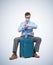 Man in a respiratory mask, shirt and tie sits with a suitcase waiting for a flight. Pandemic Travel concept.