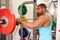 Man resting at barbells rack after weightlifting at a gym