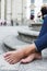 Man resting barefoot on the street