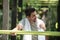 man resting after exercing on fitness bars in park