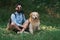 Man resting on the grass sitting crossed legs with his dog