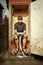 Man resting on old style latrine in wooden cabin outdoor