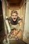 Man resting on old style latrine in wooden cabin outdoor