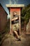 Man resting on old style latrine in wooden cabin outdoor