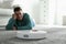 Man resting while robotic vacuum cleaner doing his work