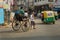 Man rickshaw puller is pulling his hand rickshaw with passenger on the street in Kolkata. India