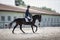 Man rider and black stallion horse galloping during equestrian dressage competition