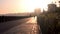 A man rides a bicycle along the promenade to meet the dawn. Silhouette of a man on a bicycle.