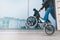 Man rides a bike on the back wheel of a BMX against a glass shop window. A teen makes tricks on a BMX bike