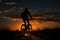 A man rides his bicycle as night descends, a peaceful journey